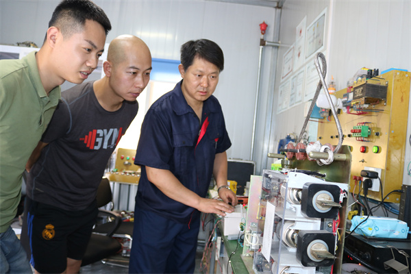 2“蓝领发明家”——崔立军 崔立军（右一）在讲解模拟防爆开关内部电路工作原理.JPG