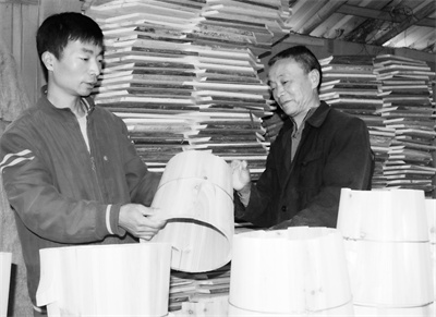 1684654256190362.jpg 3-3 4 图为父子俩在检查木桶质量。.jpg