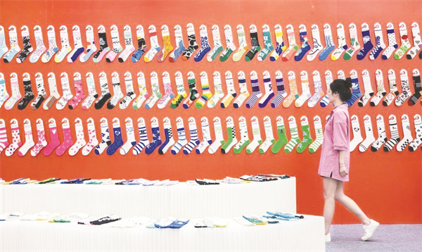 1692872345649216.jpg 1-1 1 1 一名女子在袜业博览会上参观。新华社发(郭斌摄).jpg