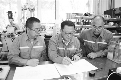 2-2 1 2 明晓峰（中）带领团队开展技术攻坚.jpg