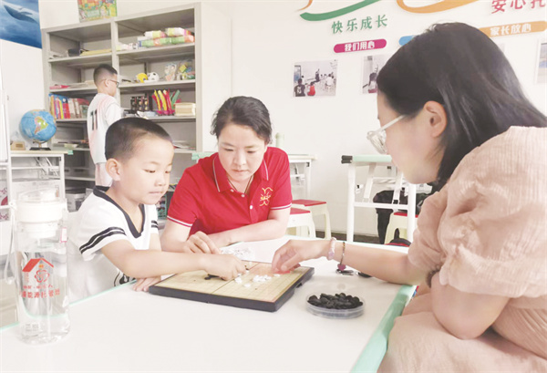 1723642878143117.jpg 5-4 6,托管老师陪职工子女学习五子棋.jpg