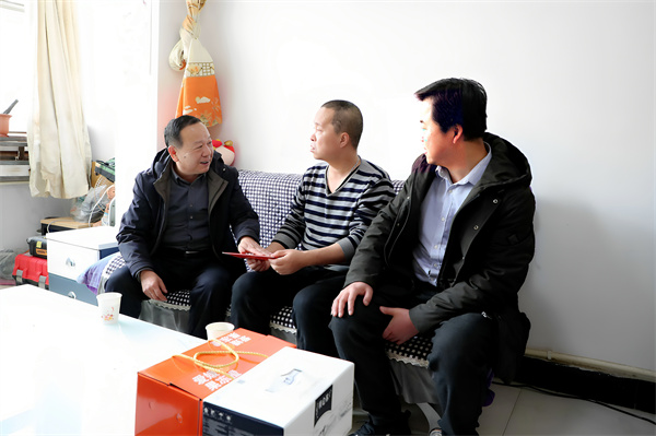 2 图为一号煤矿党委书记卢海峰（右一）提着慰问品看望机电队困难职工任峰1.JPG