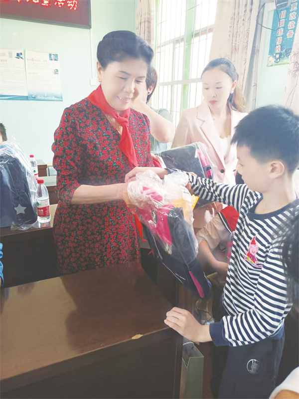 1750767650617634.jpg 1-4 4 2,6月1日,罗彩云给小朋友送去学习用具。.jpg