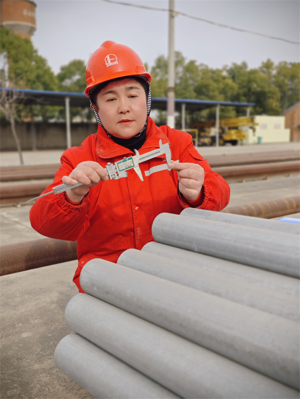 1 朱静在钢材到货现场精心测量套管参数。.jpg